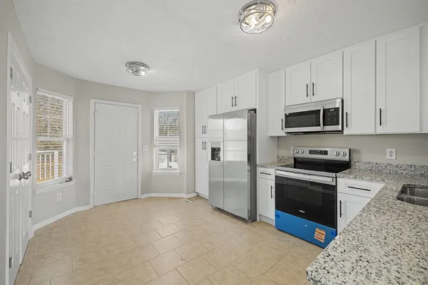 a kitchen with stainless steel appliances granite countertop a stove a refrigerator and a sink