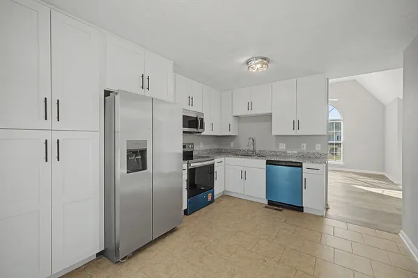 a kitchen with stainless steel appliances granite countertop a refrigerator sink and stove