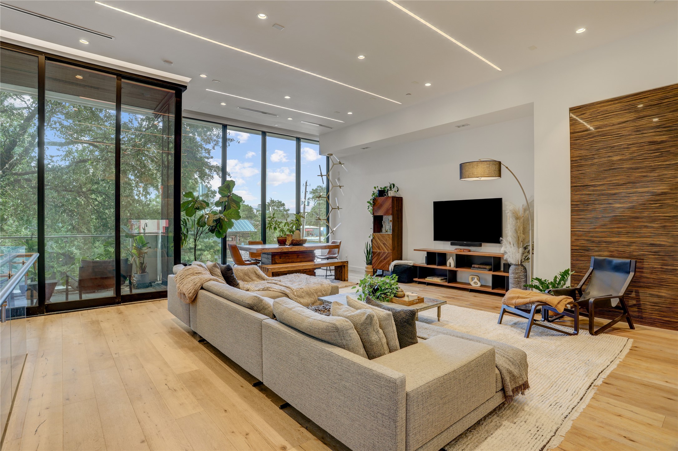 1807 Indiana Street Houston, TX 77006 - Photo 8 of 35 Great Room / Entertainment Hub: Alternative view of the stunning second-floor great room, highlighting the massive sliding glass door system that opens seamlessly to an outdoor balcony overlooking the mature trees.
