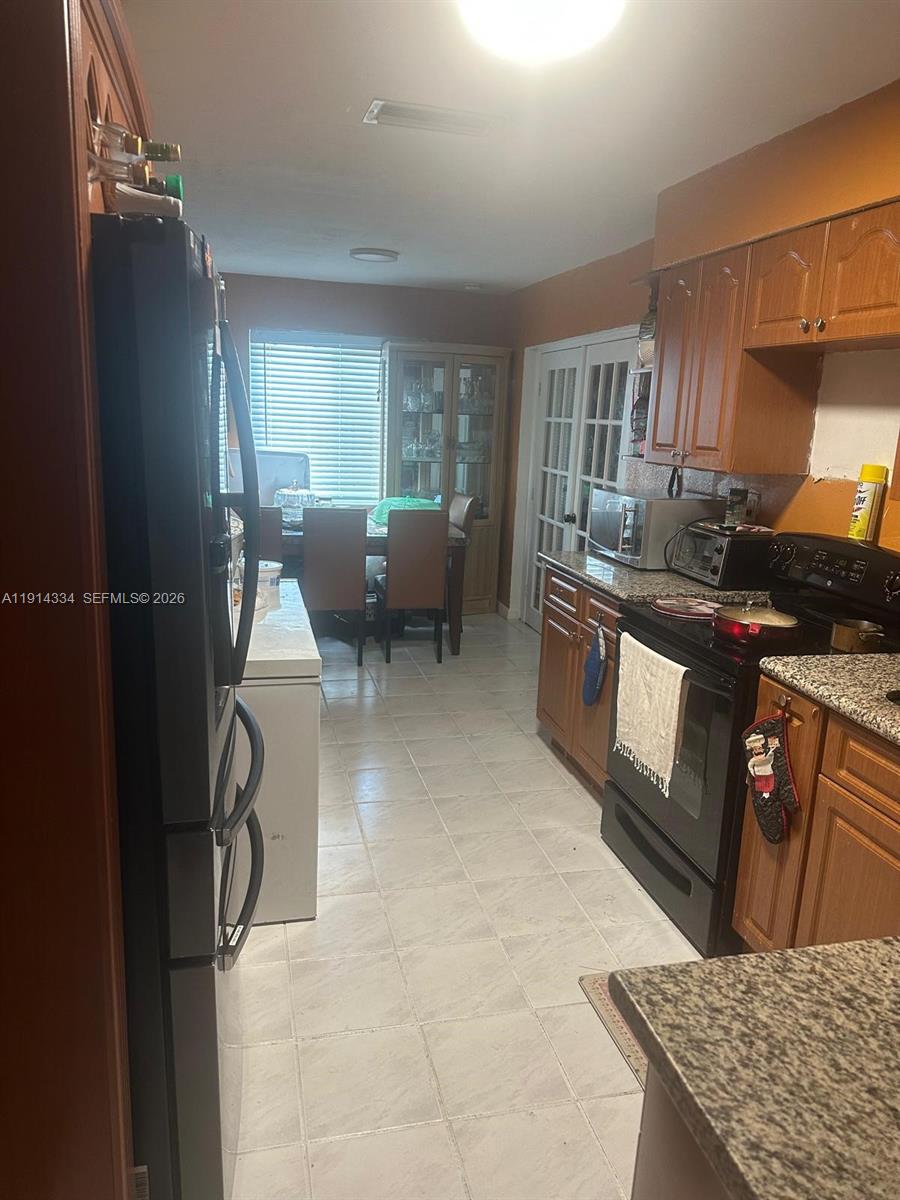 9530 Sunset Strip Sunrise, FL 33322 - Photo 7 of 11 a kitchen with granite countertop a stove and a sink