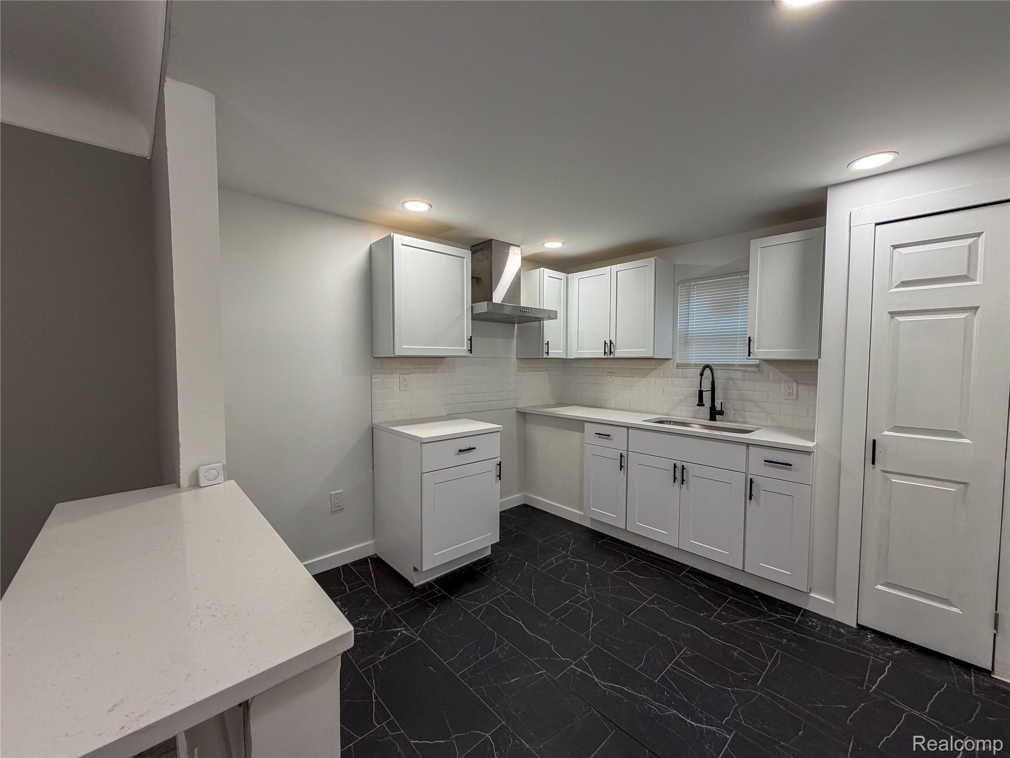 18217 Prairie Street Detroit, MI 48221 - Photo 10 of 34 Modern kitchen featuring white shaker cabinetry, black marble-look flooring, white quartz countertops, a subway tile backsplash, and recessed lighting