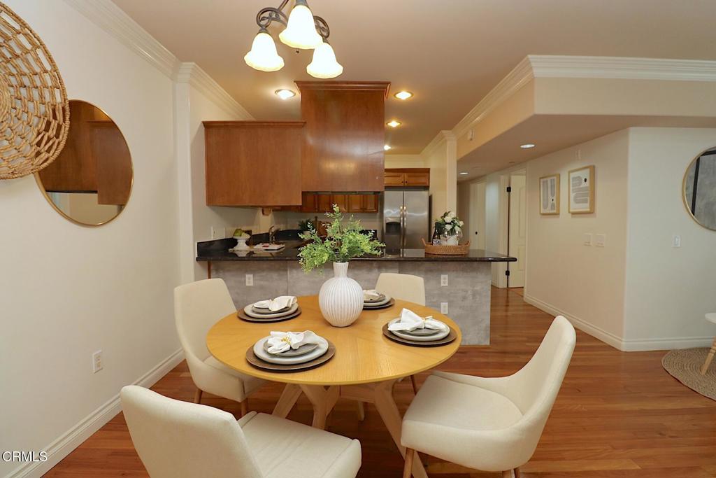 3855 Ingraham Street, Unit 204 Los Angeles, CA 90005 - Photo 3 of 35 a kitchen with stainless steel appliances a dining table and chairs with wooden floor