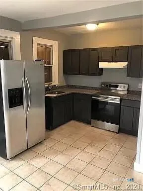 a kitchen with stainless steel appliances granite countertop a stove a refrigerator and a sink