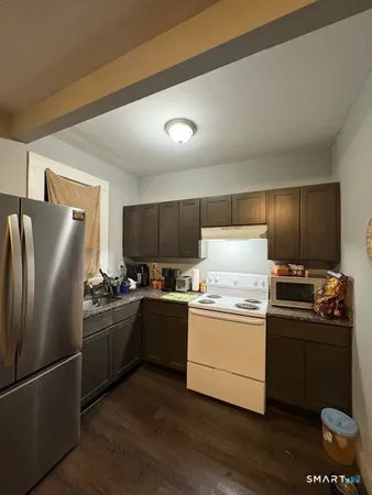 a kitchen with stainless steel appliances granite countertop a refrigerator stove and sink