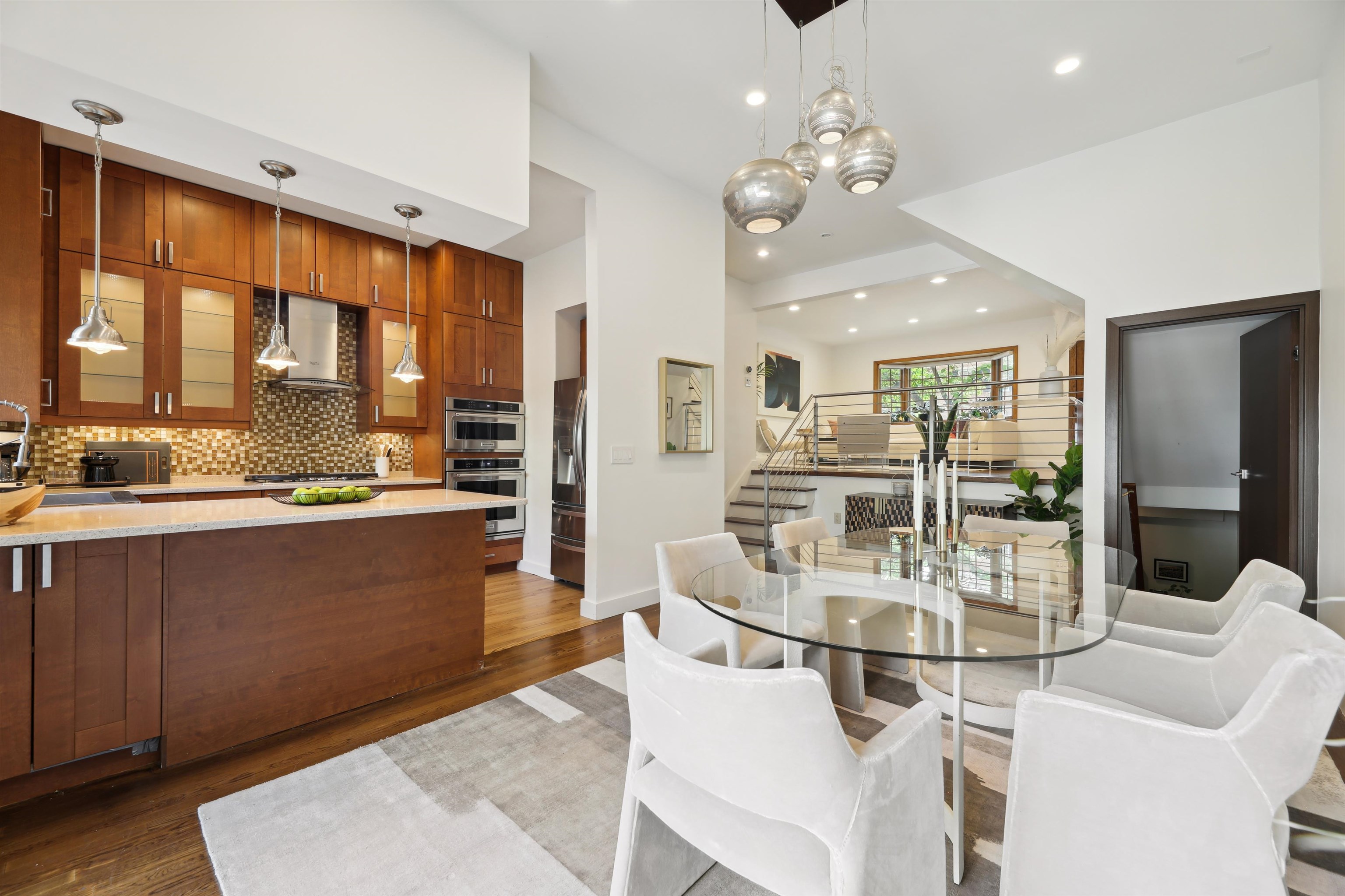 a room with stainless steel appliances kitchen island granite countertop a cabinets and a view of dining room