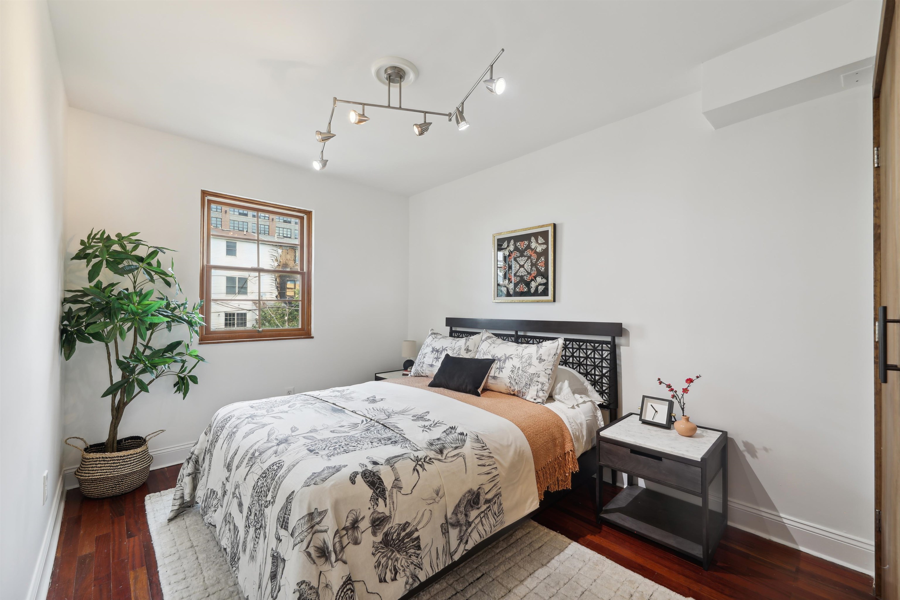 310 9th Street Jersey City, NJ 07302 - Photo 21 of 34 a bedroom with a bed and a potted plant on dresser