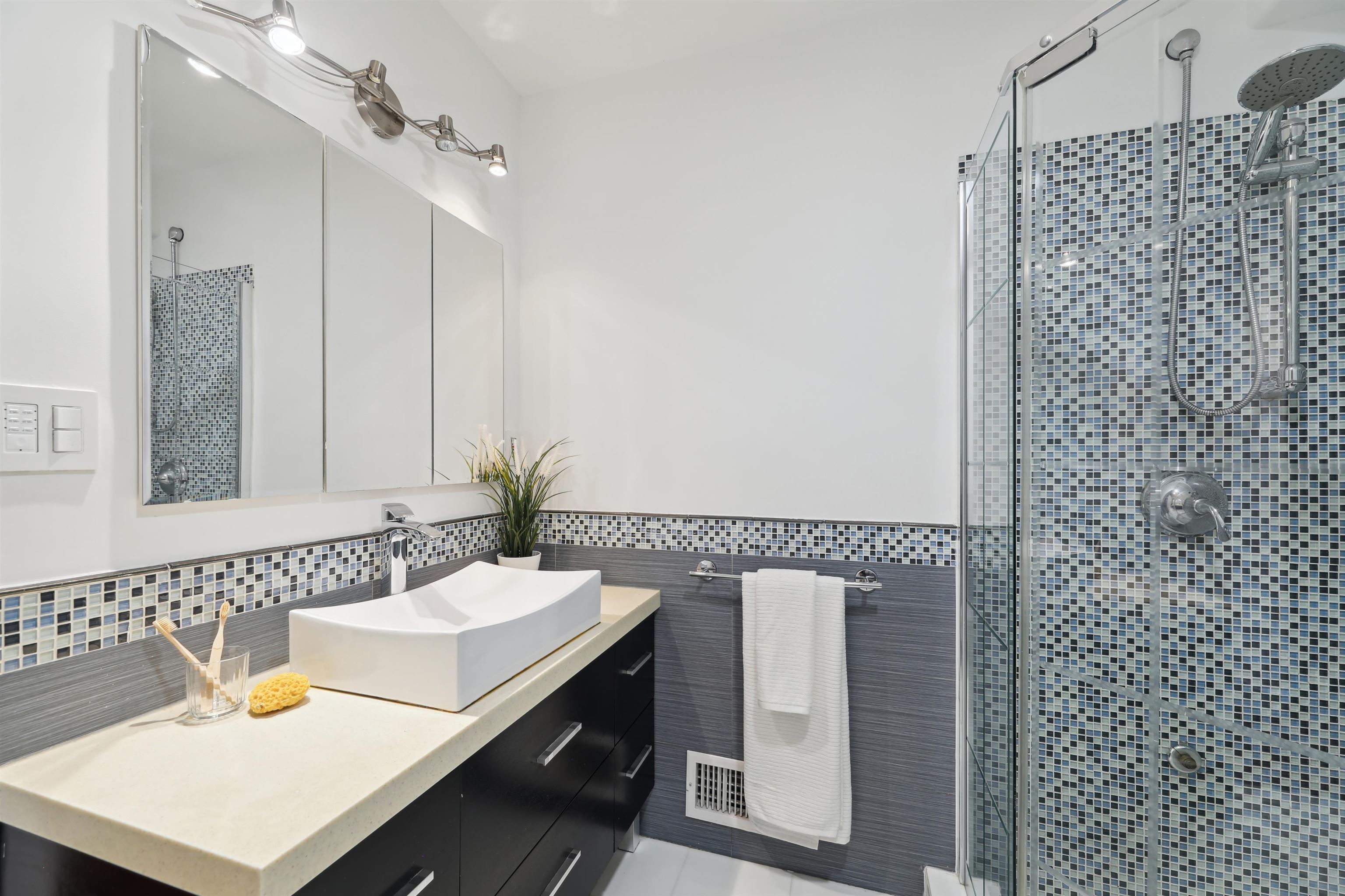 310 9th Street Jersey City, NJ 07302 - Photo 23 of 34 a bathroom with a sink a mirror and a shower
