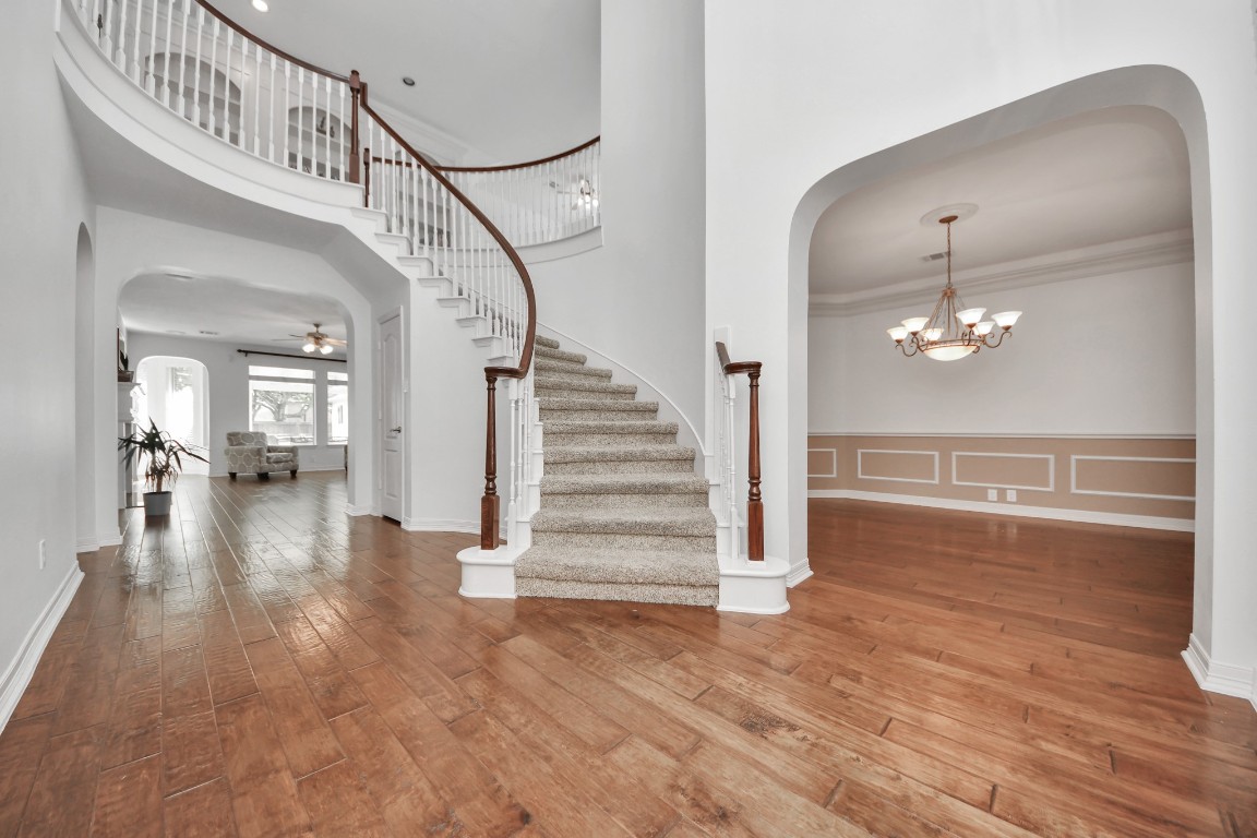 5703 Brennan Ridge Lane Katy, TX 77450 - Photo 11 of 45 a view of a hallway with stairs wooden floor and a chandelier