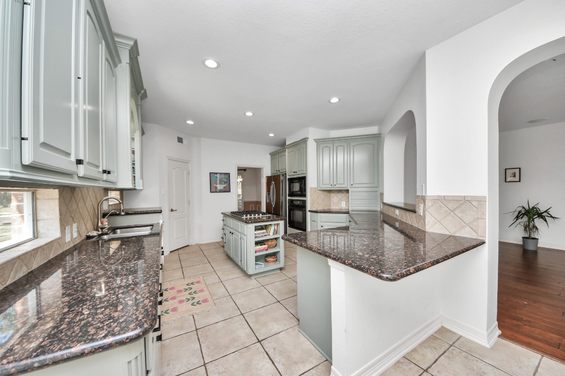 5703 Brennan Ridge Lane Katy, TX 77450 - Photo 13 of 45 a kitchen with stainless steel appliances granite countertop a sink stove and cabinets