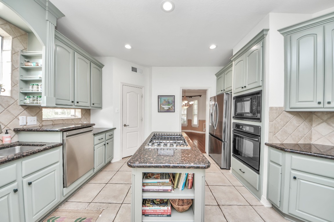 5703 Brennan Ridge Lane Katy, TX 77450 - Photo 14 of 45 a kitchen with stainless steel appliances granite countertop a stove a sink and a refrigerator