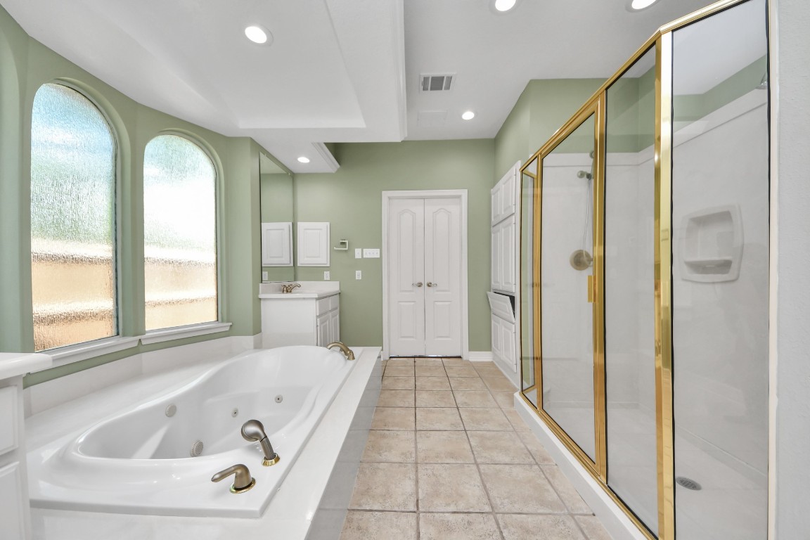 5703 Brennan Ridge Lane Katy, TX 77450 - Photo 27 of 45 a bathroom with a tub a sink and a large mirror