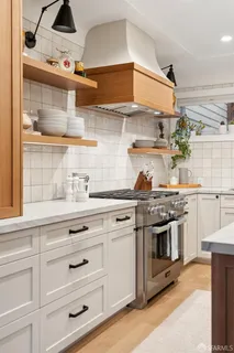 a view of a bedroom with wooden floor and window