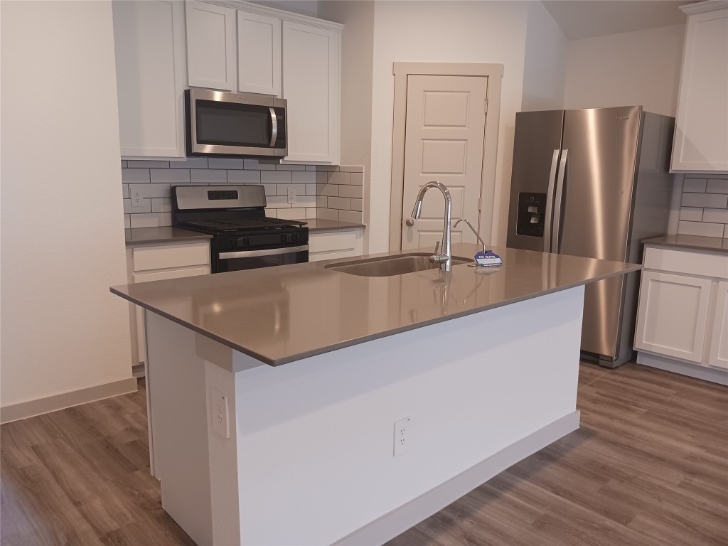 7826 Sleek Flock Lane Rosharon, TX 77583 - Photo 5 of 16 a kitchen with stainless steel appliances granite countertop a refrigerator a stove a sink and a microwave