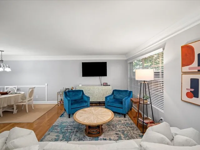 a living room with furniture a flat screen tv and a window