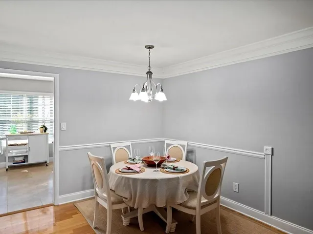 a view of a dining room with furniture wooden floor and chandelier