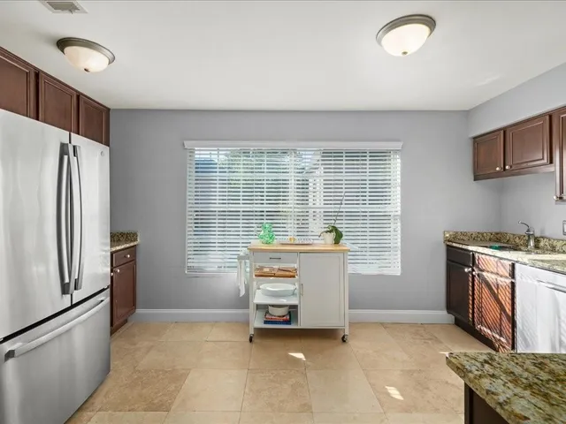 a kitchen with stainless steel appliances granite countertop a refrigerator stove and sink