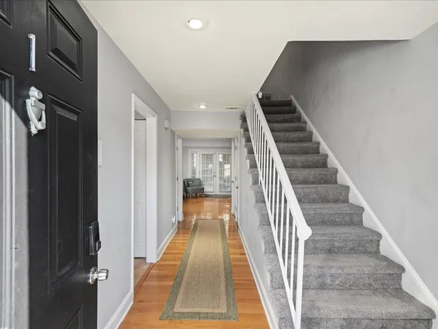 a view of a hallway with wooden floor and entryway