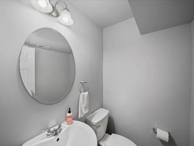 a bathroom with a toilet a sink and a mirror
