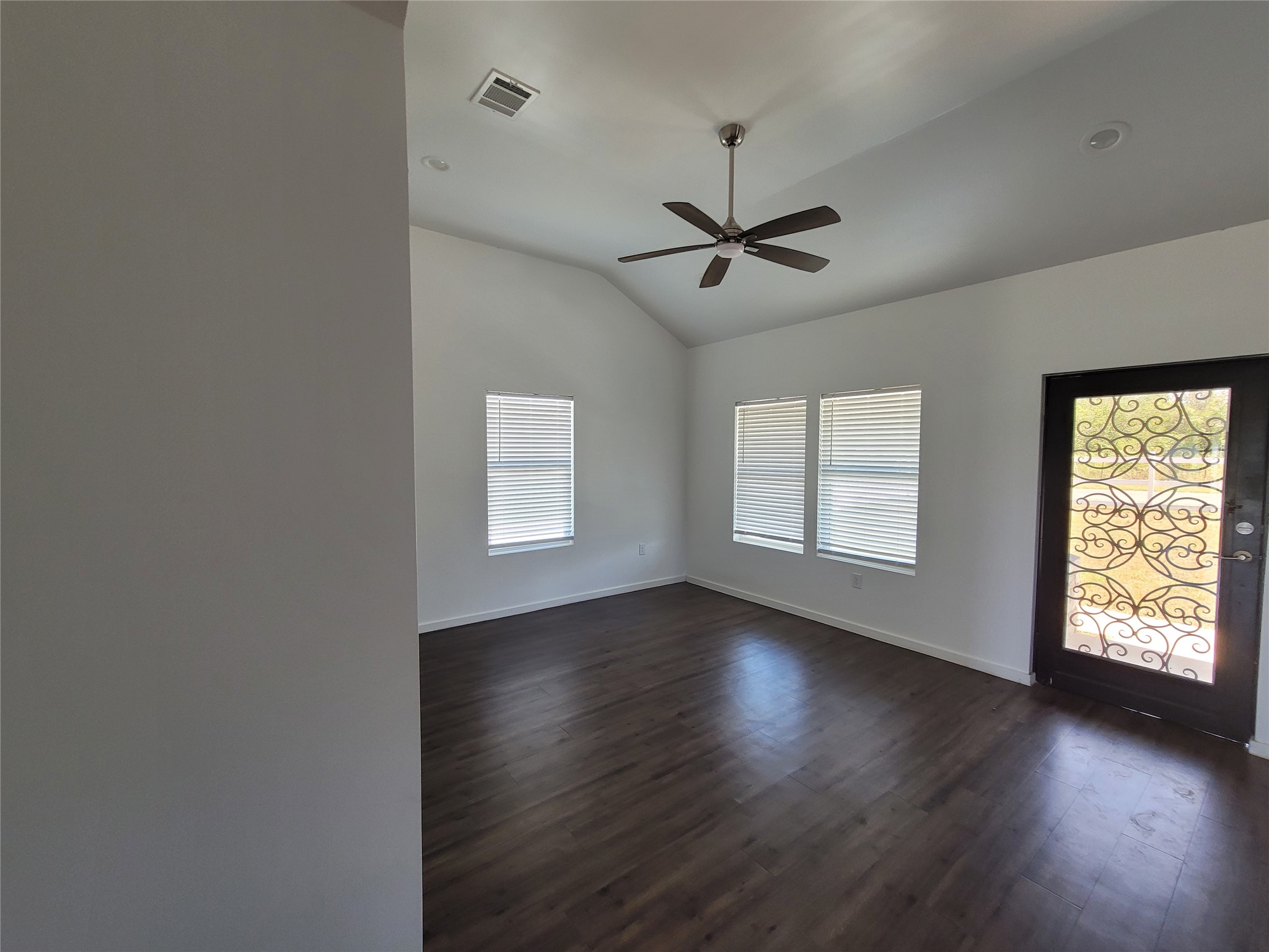 422 A Road Stockdale, TX 78160 - Photo 7 of 40 Enter into a bright, open-plan living area with vaulted ceilings and rich wood flooring.