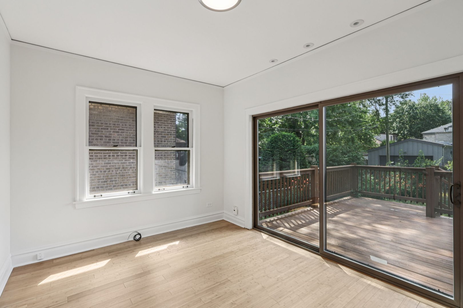5253 Cleveland Street Skokie, IL 60077 - Photo 13 of 57 a view of an empty room with wooden floor and a window