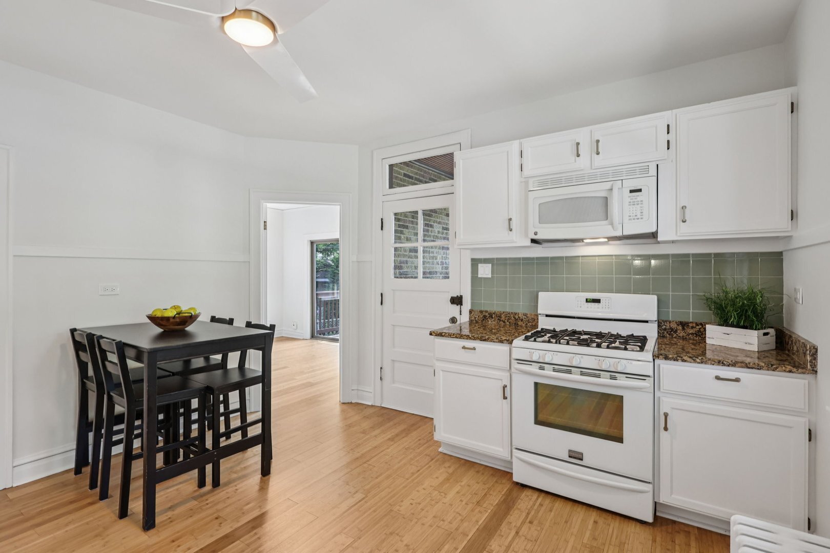5253 Cleveland Street Skokie, IL 60077 - Photo 15 of 57 a kitchen with granite countertop a stove a sink and chairs