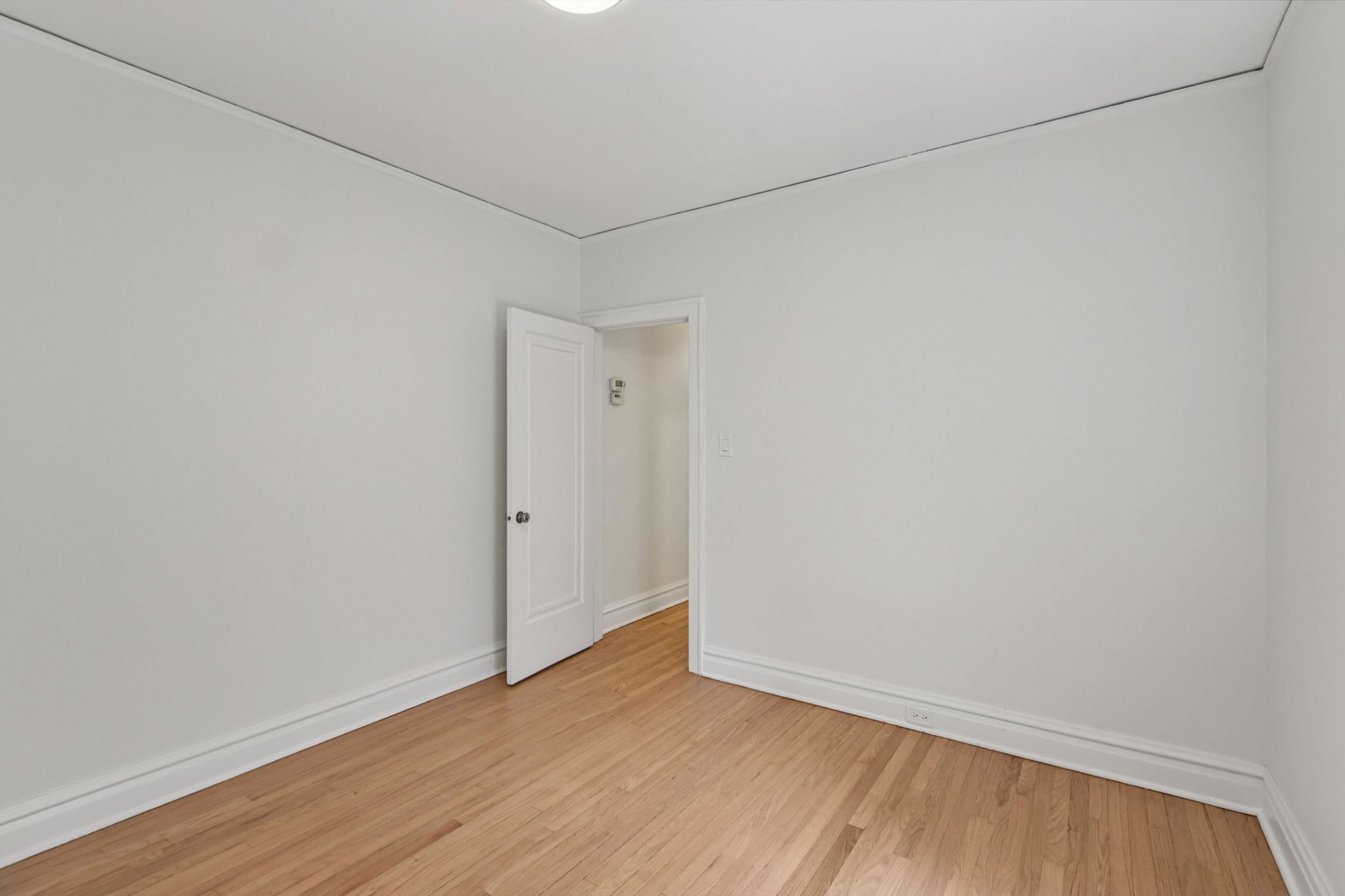 5253 Cleveland Street Skokie, IL 60077 - Photo 22 of 57 a view of an empty room with wooden floor