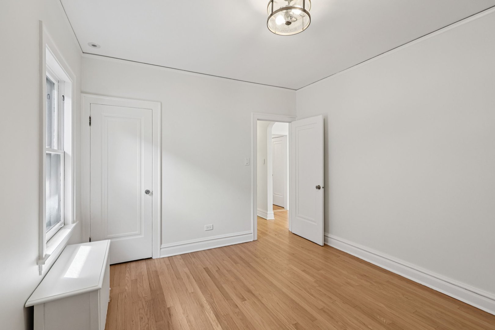 5253 Cleveland Street Skokie, IL 60077 - Photo 26 of 57 a view of an empty room with wooden floor and a window