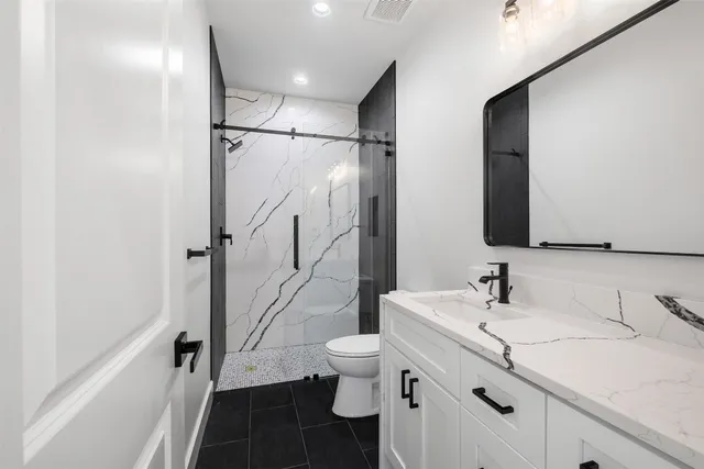 a bathroom with a sink a toilet and a large mirror