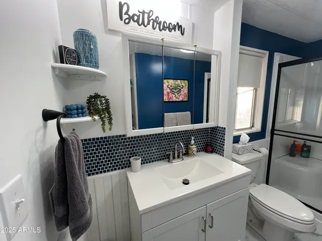 a bathroom with a sink a toilet and a mirror