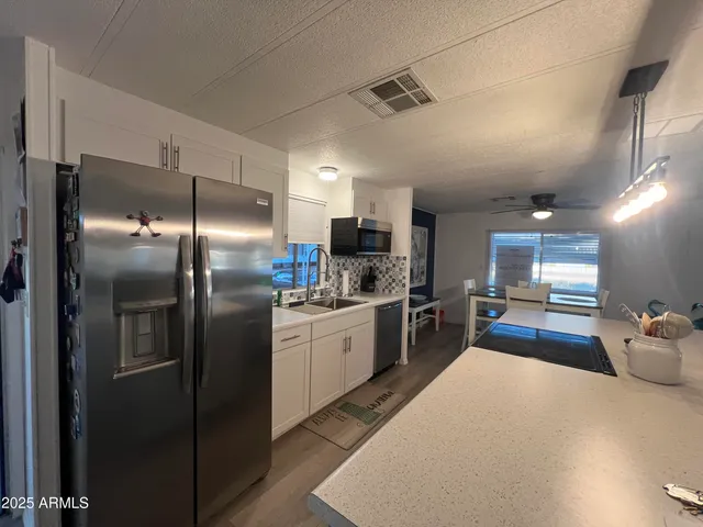 a kitchen with stainless steel appliances kitchen island granite countertop a refrigerator and a stove