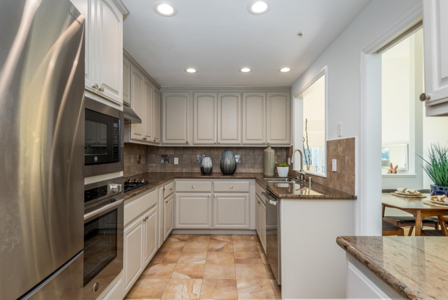 1040 Continentals Way, Unit 12 Belmont, CA 94002 - Photo 7 of 30 a kitchen with stainless steel appliances granite countertop a sink stove and refrigerator