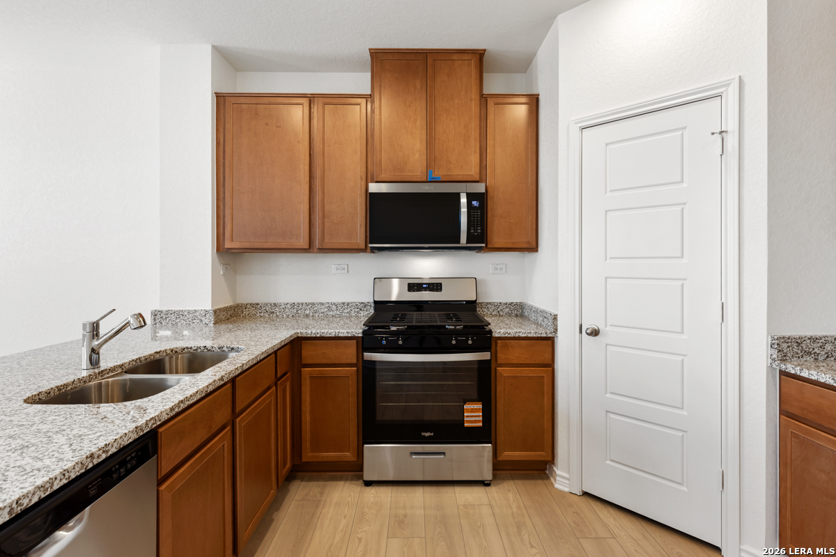 10045 Jagger Avenue Converse, TX 78109 - Photo 14 of 28 a kitchen with a sink stove and cabinets