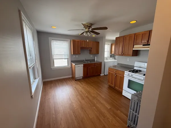 a kitchen with stainless steel appliances granite countertop a stove a refrigerator a sink a microwave oven with wooden floor and cabinets