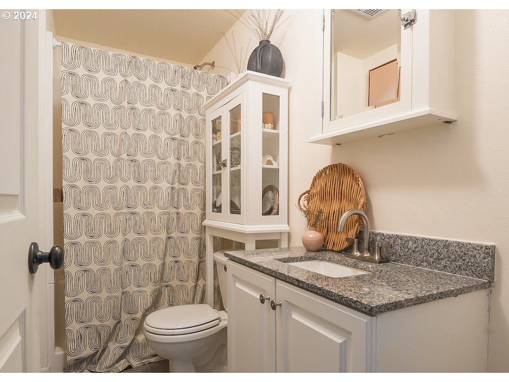 2097 Southwest Brixton Place Gresham, OR 97080 - Photo 35 of 43 a bathroom with a granite countertop sink a toilet and a mirror