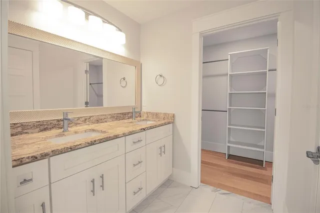 a bathroom with a granite countertop sink and a mirror