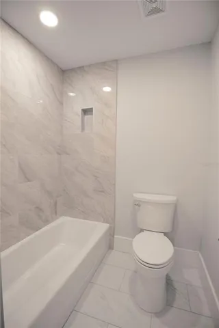 a bathroom with a toilet and bathtub