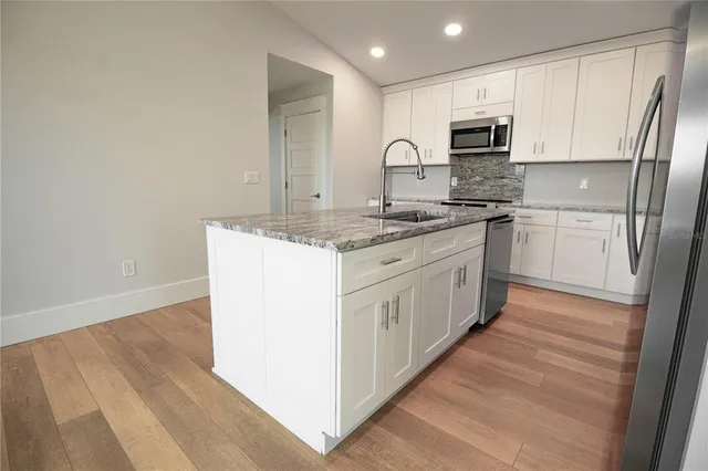 a kitchen with stainless steel appliances granite countertop a stove a sink and a refrigerator