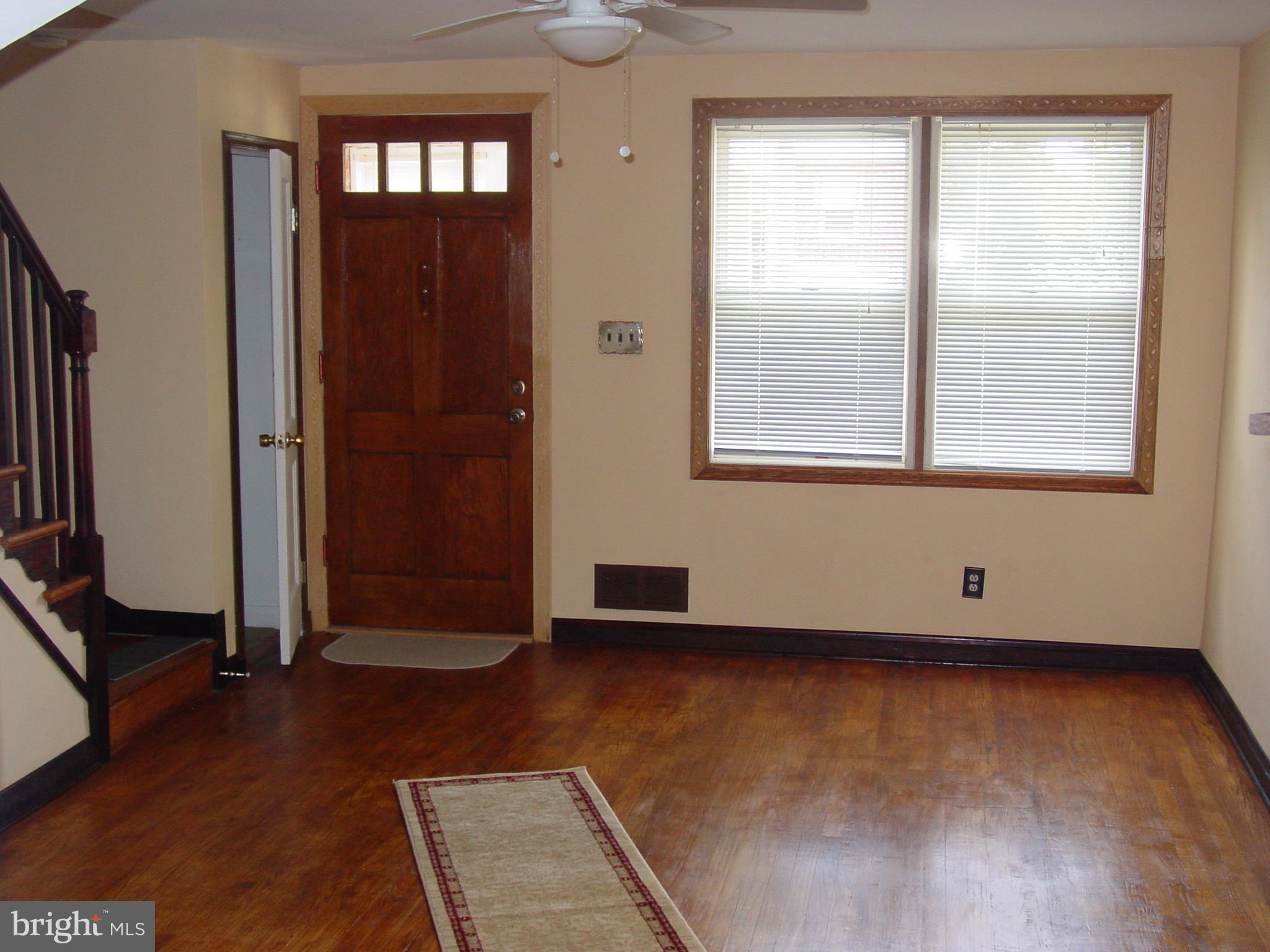 7406 Kirtley Road Baltimore, MD 21222 - Photo 19 of 21 an empty room with wooden floor and windows