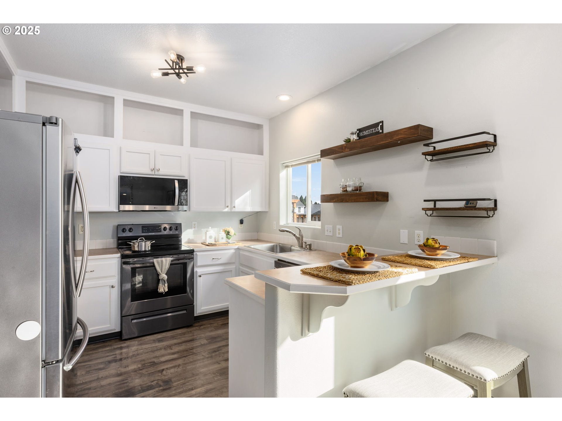 51692 Southeast 3rd Street Scappoose, OR 97056 - Photo 8 of 22 a kitchen with stainless steel appliances a sink a stove a refrigerator cabinets and a window