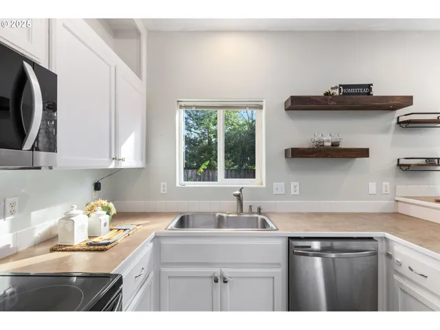 a kitchen with stainless steel appliances white cabinets and a sink