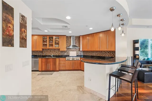 a kitchen with stainless steel appliances granite countertop a stove a sink and a refrigerator