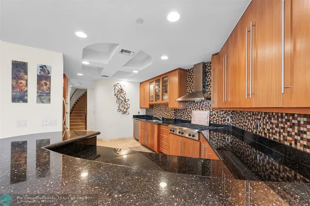 a kitchen with stainless steel appliances granite countertop a stove a sink and a microwave