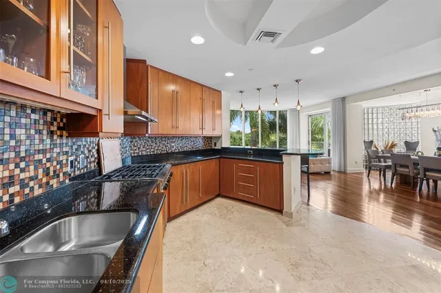 a kitchen with stainless steel appliances kitchen island granite countertop a sink and cabinets