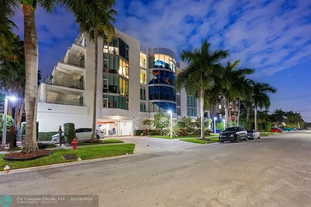 front view of house with a yard and palm trees