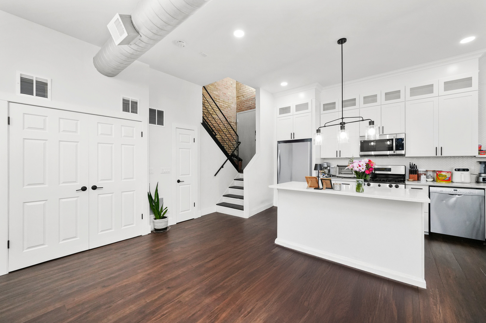 2101 West Rice Street, Unit 100 Chicago, IL 60622 - Photo 3 of 32 a kitchen with stainless steel appliances granite countertop a refrigerator a stove a microwave and a wooden floors