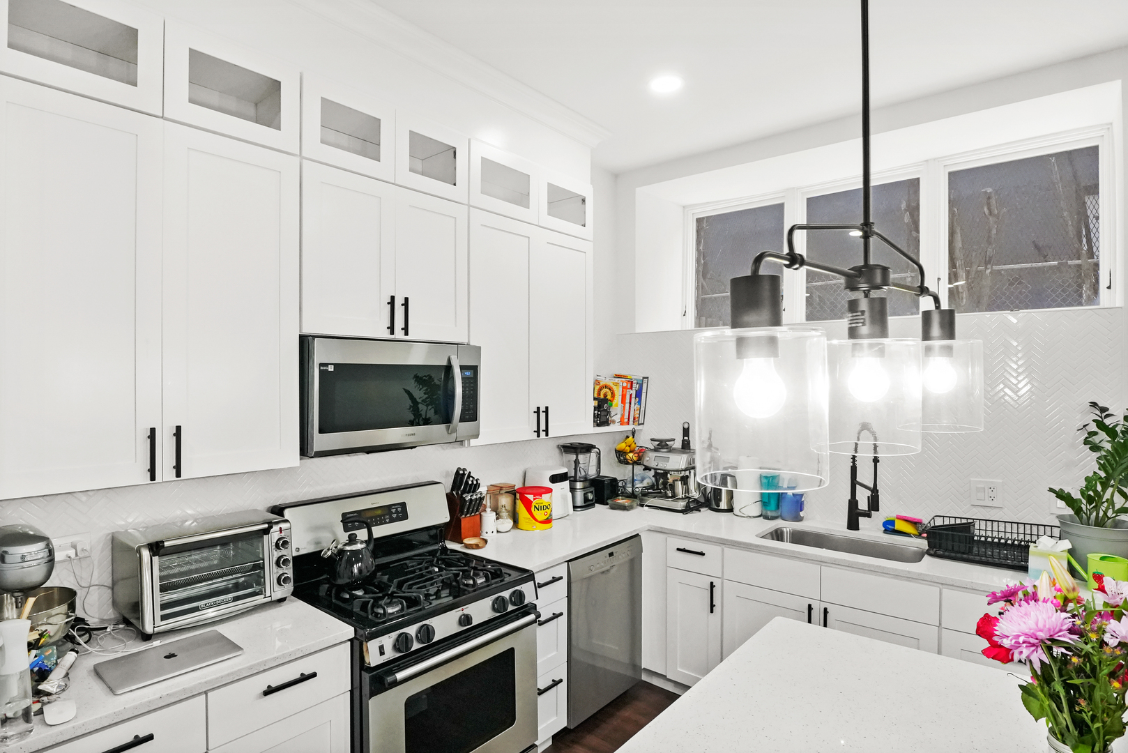 2101 West Rice Street, Unit 100 Chicago, IL 60622 - Photo 8 of 32 a kitchen with granite countertop a sink stainless steel appliances and cabinets