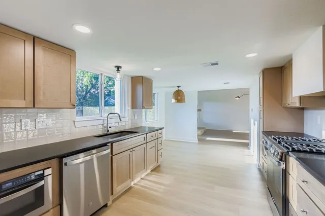 a kitchen with granite countertop a sink and a stove
