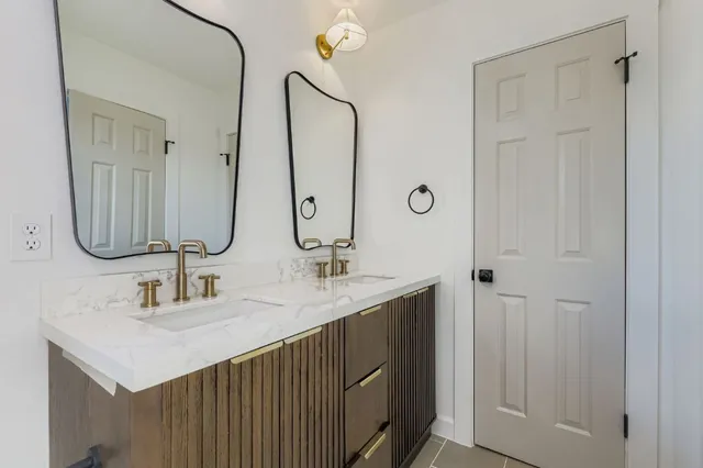 a bathroom with double vanity sinks and a mirror