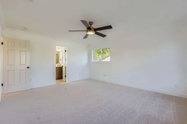 an empty room with a window and a ceiling fan