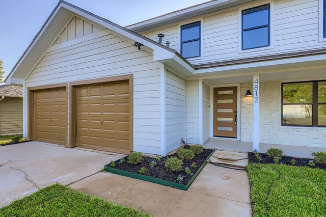 a view of a yard in front of a house with large tree